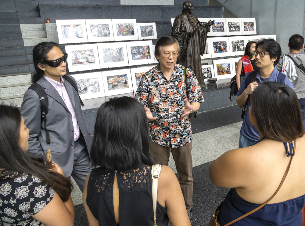 Corky Lee speaking to a group of people. Courtesy of James Sobredo.