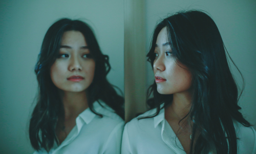 Woman looking at her own reflection Woman looking at her own reflection